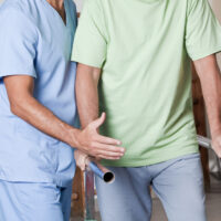 Senior man having ambulatory therapy with his therapist.